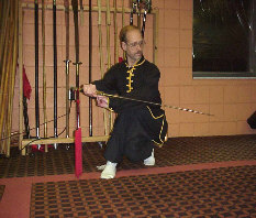 Student practicing with a rope dart weapon in a low stance