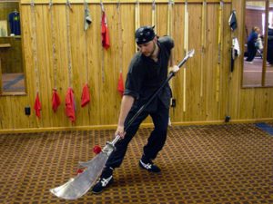Student practicing with a long-handled kwan dao pole weapon