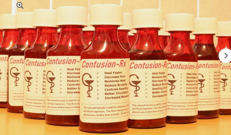 Bottles of Dit Da Jow liniment, Contusion-Rx, lined up on a shelf