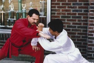 Two students demonstrating a self-defense technique outside the school